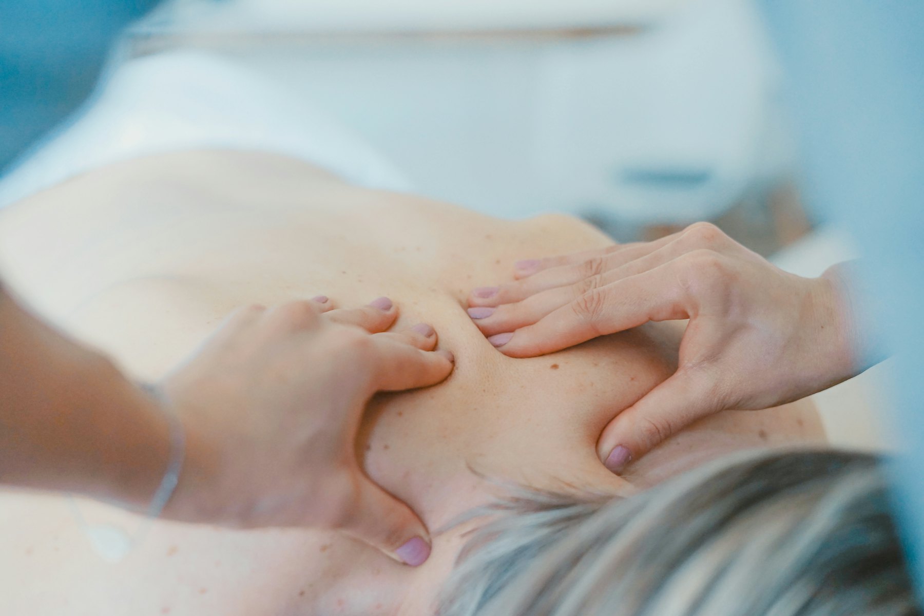 Therapeutin behandelt den Rücken einer Patientin