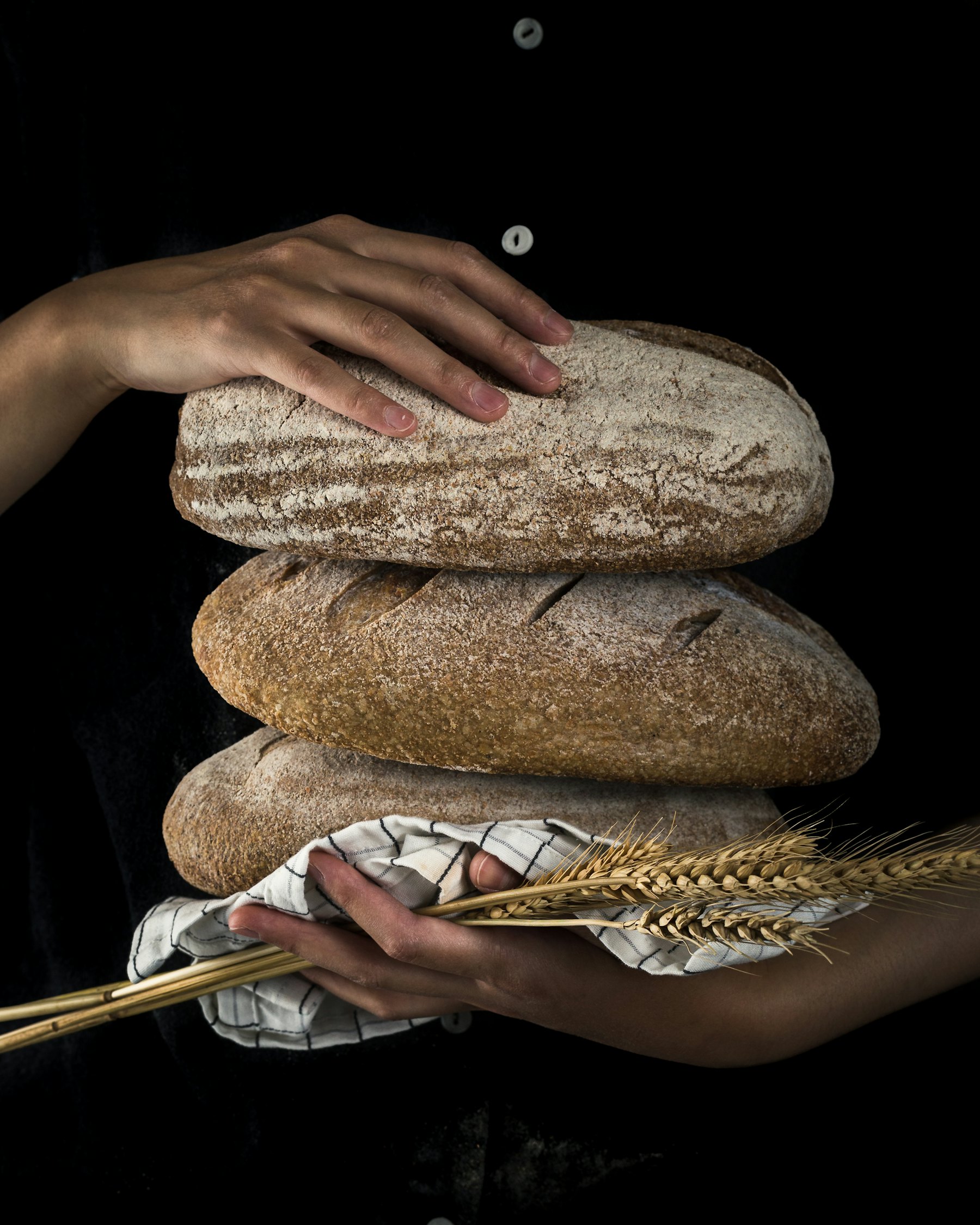 Bäcker hält ein frisches Brot