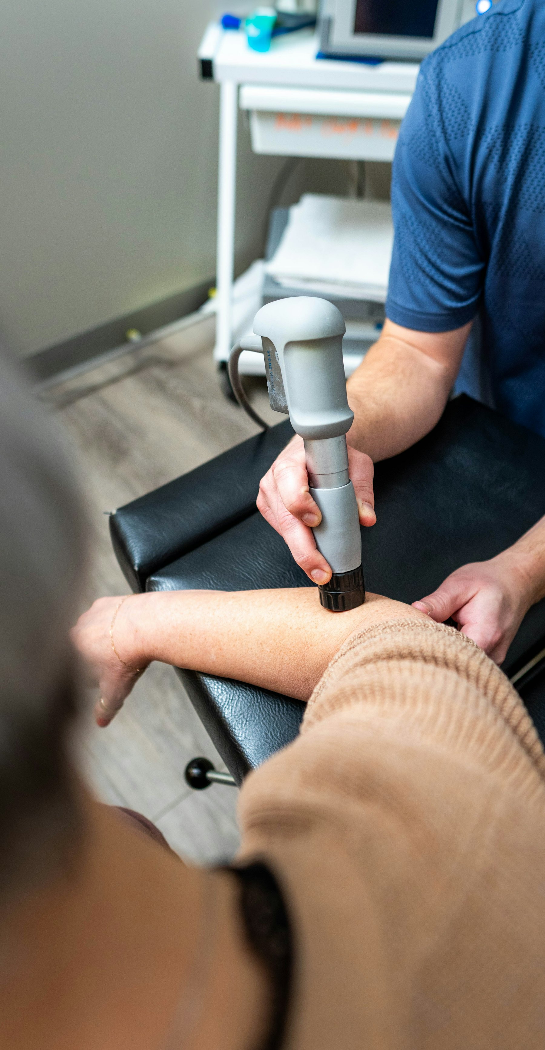 Therapeutin behandelt den Arm eines Patienten